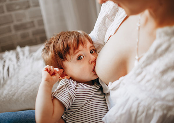 Shows an image of a woman breastfeeding her infant