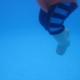 Shows the bottom portion of a toddler's body floating in the water. The child is wearing a life jacket.